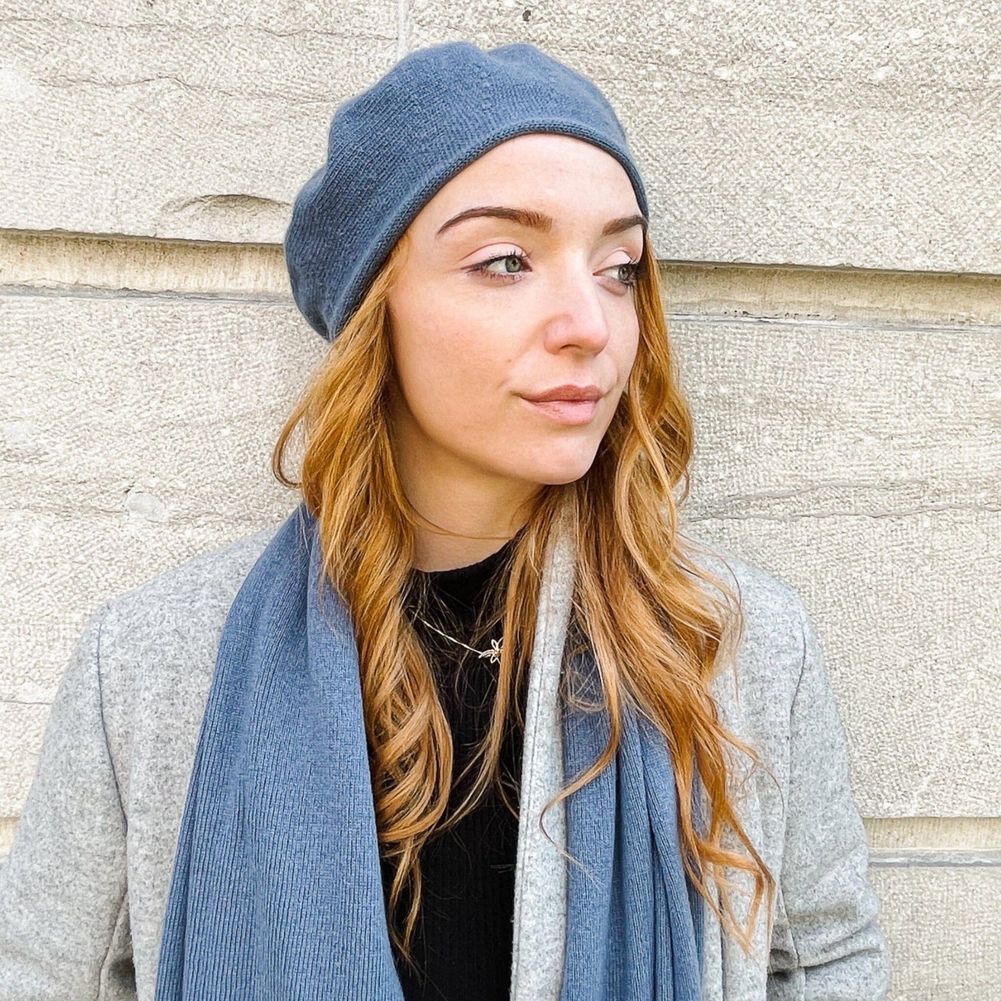 A woman wearing a blue cashmere beret and scarf