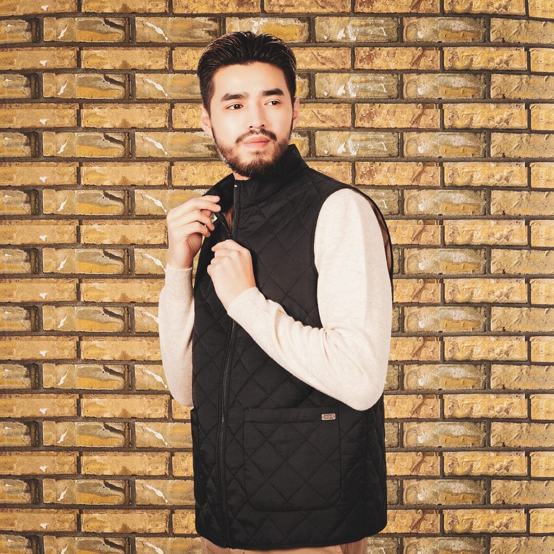 A man modelling the unisex outdoor vest in front of a brick wall
